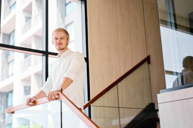 Ofis iç rahat giyen genç yakışıklı iş adamı.