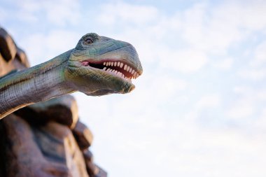 Dinozor modeli heykel gökyüzü arka plan üzerinde genel Park.