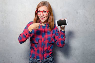 Smartphone perde ile kopya alanı üzerine işaret ekose gömlekli çekici genç kadın.