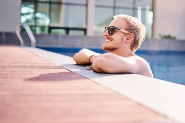 Yüzme havuzunda mutlu genç adam.