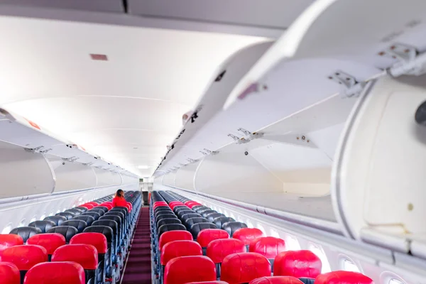 Modern plane interior with red seats.