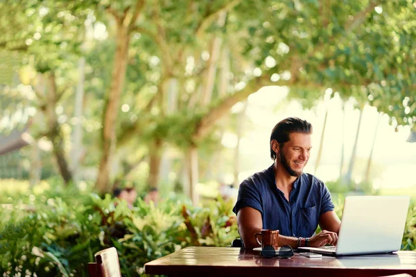 年轻胡子男子使用笔记本电脑 而坐在夏季露台 — 图库照片