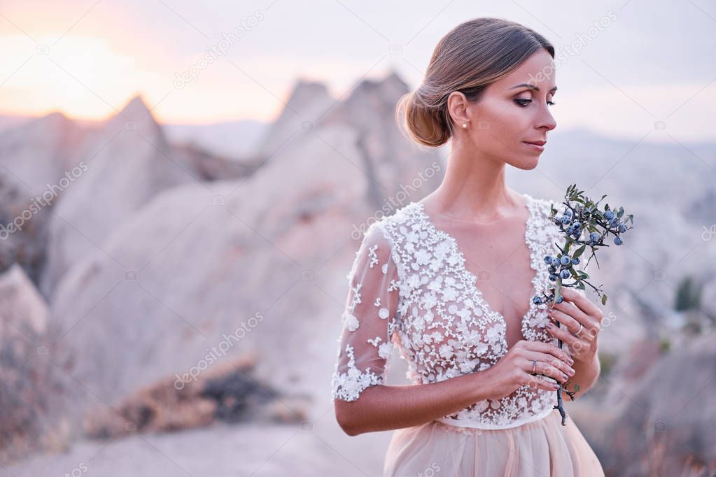 Fairy and sensual portrait of pretty young woman against mountains view.