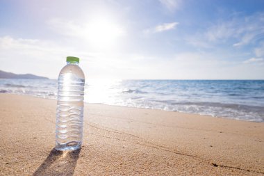 İçme suyu deniz plajın kumları üzerinde plastik şişe.