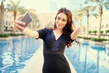 Downtown Dubai selfie alarak smartphone kullanan genç ve güzel kadın.