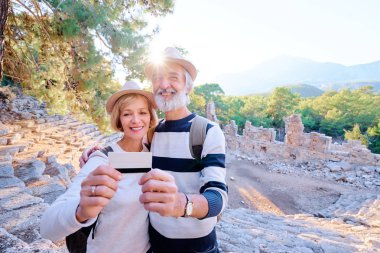 Üst düzey seyahat çift holding kredi kartı eski gezi arka plan üzerinde dururken.