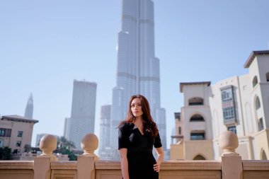 Güzel genç kadın çekici gülümseme ve uzun saç Downtown Dubai üzerinde yürüme.