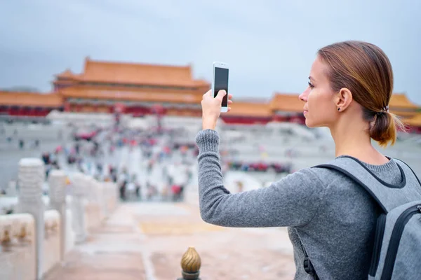 紫禁城の写真を撮るのスマート フォンを持つ若い女性 — ストック写真