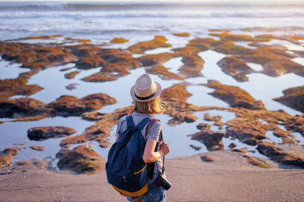 Молодая женщина с камерой и рюкзаком прогулка по морскому пляжу
.