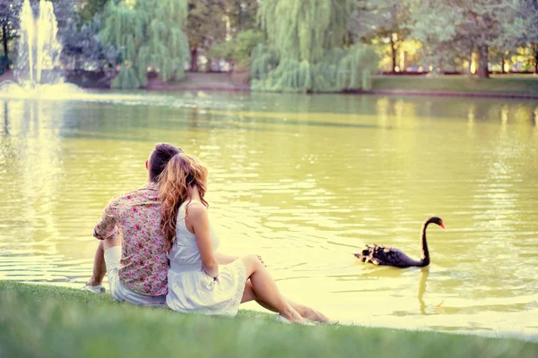 爱的夫妇坐在一起在草附近湖 — 图库照片