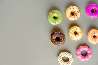 Gri arka plan üzerinde renkli donut topluluğu.