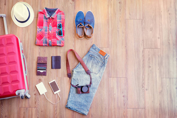 Different male clothes, accessories and gadgets on wooden floor
