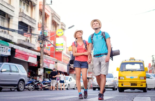 一緒にアジアのストリート上を歩くバックパッカーのカップル — ストック写真