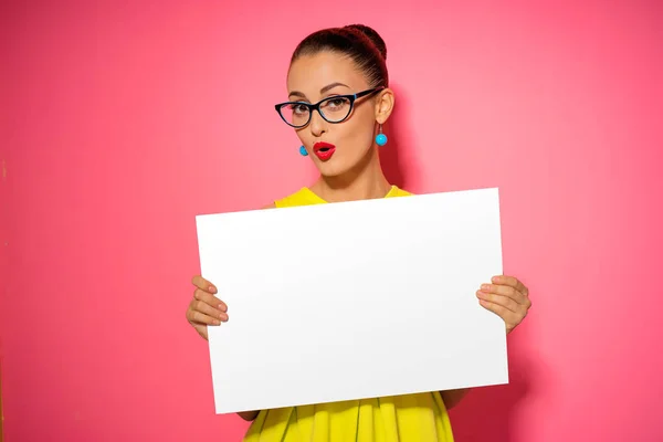 Pretty young excited woman holding empty blank board