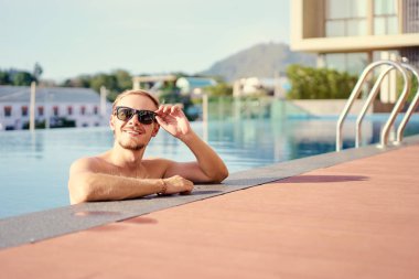 Yüzme havuzunda mutlu genç adam.