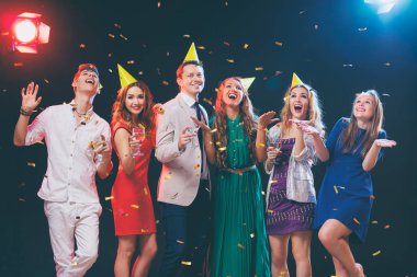 Altı mutlu gülümseyen arkadaşlar eğlenmeye konfeti arasında birlikte gece kulübünde Grup.