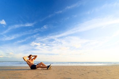 Okyanus plaj egzersizi yapan genç erkek