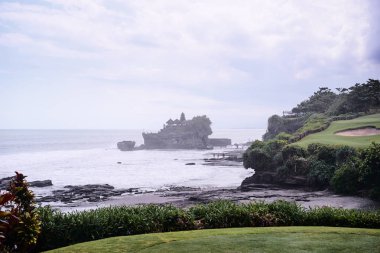  Antik Hinduizm Tapınağı Tanah lot bulutlu gökyüzü karşı kayaya. Bali Adası, Endonezya.