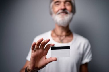 Plastik kredi kartı tutan kıdemli sakallı adam