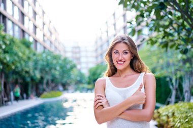 Kat mülkiyeti yüzme havuzu karşı duran mutlu genç kadın.