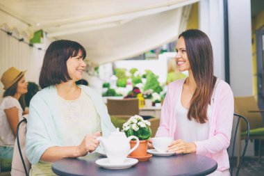 Yaşlı kadın ve onun yetişkin kızı kafede çay içme.