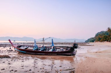 Geleneksel Tay longtail tekne ile denizde güzel gün batımı.
