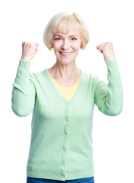 上げた腕を維持する年配の女性を笑顔で立っている白い背景に分離しながらカメラ目線 — ストック写真
