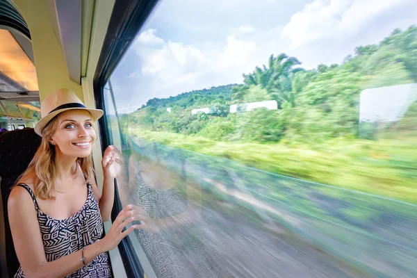 若い可愛い女性が窓のそばに座って電車旅行 — ストック写真