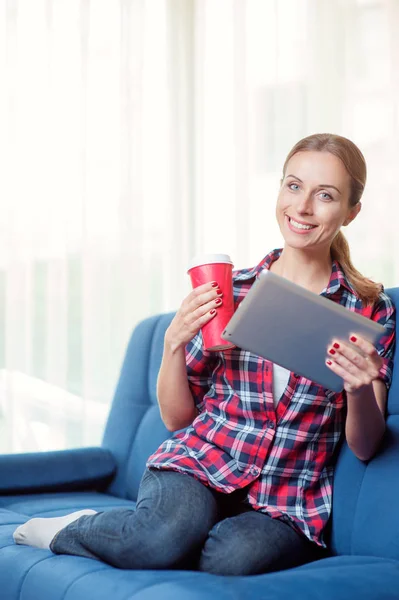 Wanita Muda Yang Cantik Tersenyum Menggunakan Tablet Sambil Minum Kopi — Stok Foto