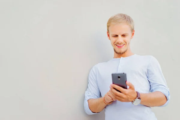 Schöner Junger Bärtiger Mann Mit Smartphone Und Lächelt Während Vor — Stockfoto