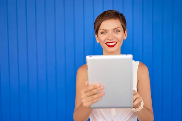 Színes Studio Segítségével Tabletta Számítógép Kék Falnak Csinos Fiatal Portréja — Stock Fotó