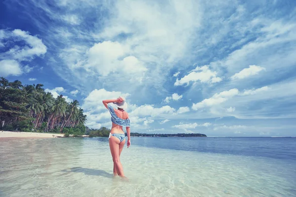 在美丽的热带白色沙滩上漫步的年轻女子的后景色 — 图库照片