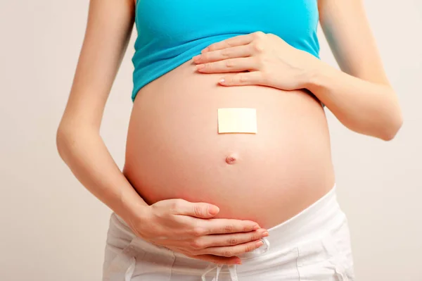 Brzuch Młoda Kobieta Ciąży Naklejką Nim Białym Tle — Zdjęcie stockowe