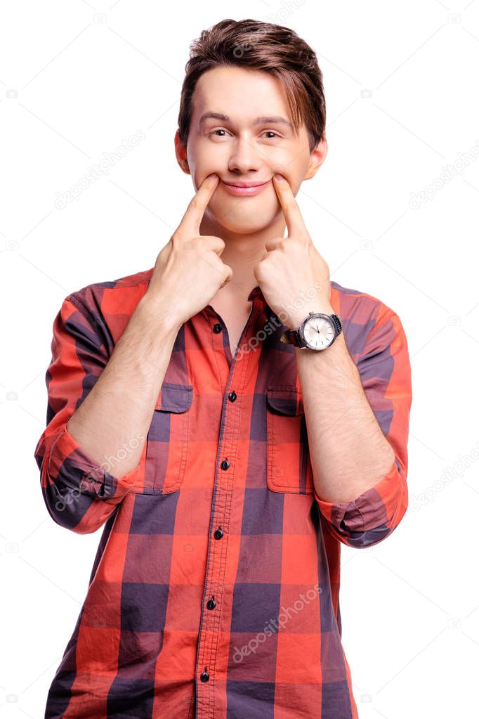 Handsome young man keeping smile with his fingers