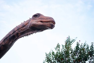 Dinozor modeli heykel gökyüzü arka plan üzerinde genel Park.