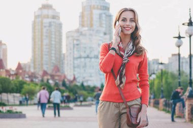 Çekici genç kadın üzerinde cep telefonu açık havada söz.