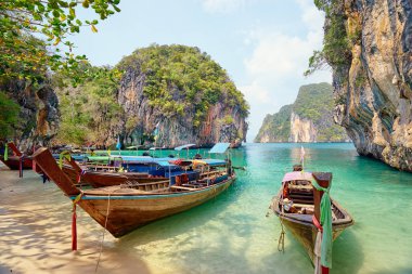Geleneksel longtail tekneler, kayalar, uçurumlar, tropikal plaj güzel manzarasına. Krabi, Tayland.