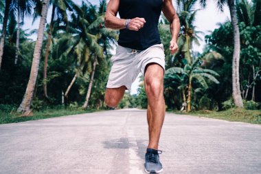 Güçlü delikanlı palmiye ağaçları altında çalışan.