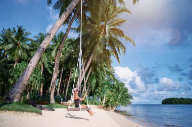 Mutlu genç kadın deniz manzarayı palm grove adlı sallanan şapkalı.
