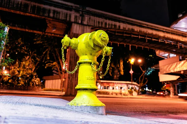 close-up view of old yellow fire hydrant for emergency fire access on the city street.