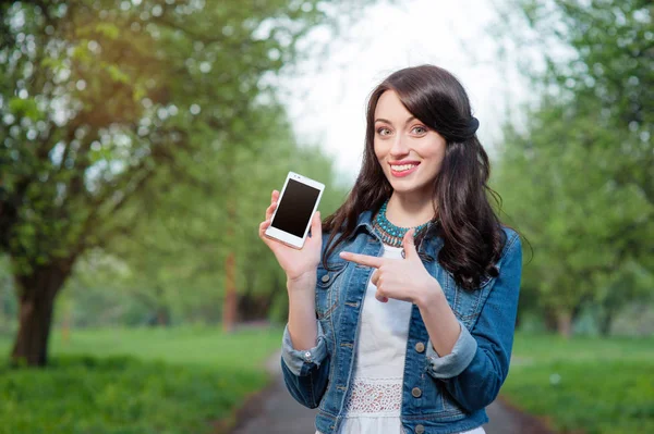 Selbstbewusste Junge Kaukasierin Zeigt Auf Ihren Handybildschirm Und Lächelt — Stockfoto