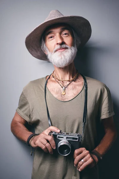 工作室肖像英俊的老人与灰色胡子和帽子持有照片相机 — 图库照片