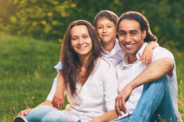 Портрет международной семьи, сидящей вместе в парке
