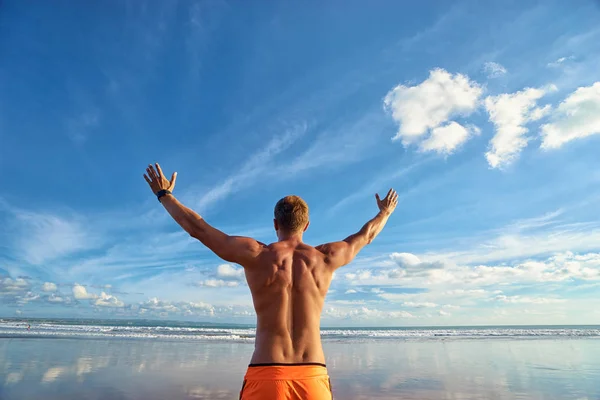 Joven Hombre Guapo Fuerte Levantando Las Manos Playa Contra Cielo — Foto de Stock