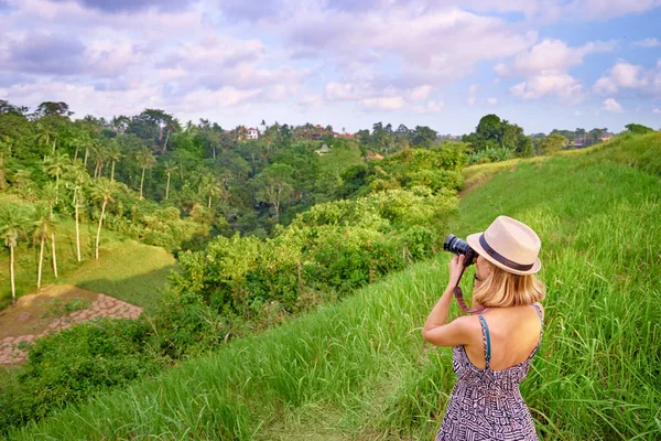 拍照的年轻妇女与她的照相机享受热带风景 — 图库照片