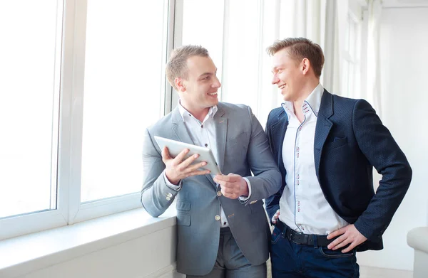 Dois Homens Bonitos Sorridentes Usando Computador Tablet Enquanto Discutem Algo — Fotografia de Stock