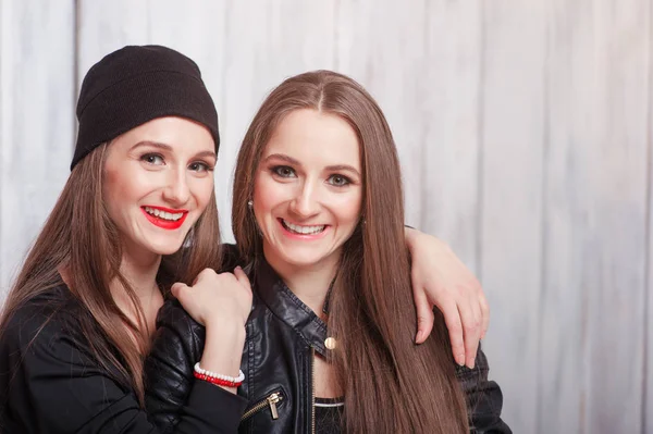 Duas Belas Mulheres Jovens Sorridentes Juntos Contra Fundo Madeira Cinza — Fotografia de Stock