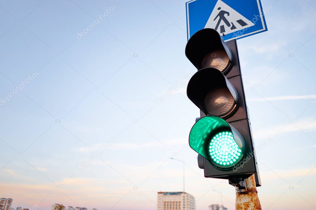 close-up view of traffic light with green light against the sky.