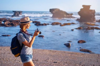 Kamera güzel okyanus plaj üzerinde tutan genç ve güzel kadın.