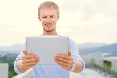 Dijital tablet açık kullanma yakışıklı genç.